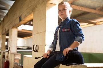 Girl sitting in the stable