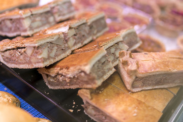 Corned beef and potato tray bake pasties with shortcrust pastry on a butchers market stall in Yorkshire, England
