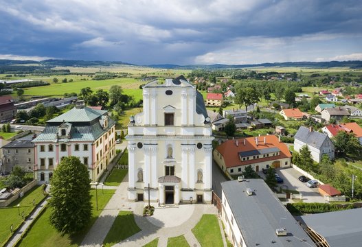 Aerial view of Baroque style Church of St. Joseph and Abbot House in Krzeszow, Poland against dark rainy sky. The church is a part of former Cistercian abbey complex