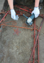 Decommunization: the man is cutting off the communism symbol from the old metal frame 