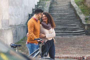 Obraz premium Happy young couple with a bicycle on sunny autumn day in the city. 
