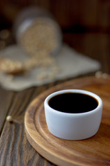 White ceramic bowl with soy sauce on kitchen.