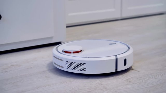 A robotic vacuum cleaner slides across the room.