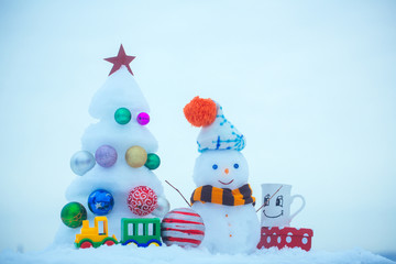Christmas tree with decorations, toy train, cup and present box