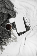 woman's bed top view on a lazy sunday morning in cold weather . Lifestyle with book, coffee and...