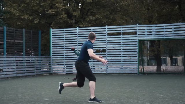 Slow motion of two men practising passing ball while playing American football on field