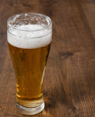 Glass beer on wood background with copyspace