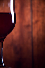 A glass of red wine on an old wooden rustic background