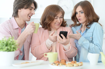 Obraz na płótnie Canvas Happy family using mobile phone together