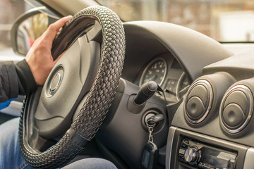salon vehicle interior, the man's hand of the driver on the steering wheel and the view of the...