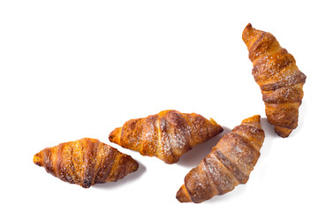 Four croissant sprinkled with powdered sugar isolated on a white background