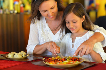 mother and daughter eating in cafe
