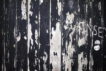 Vandalised, cracked and peeling paint on boarded up wood windows creates a grunge texture background