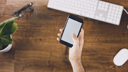 pov shot of hand holding a smartphone with blank screen for copy space