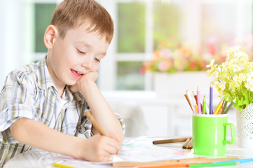 little boy drawing with pencil