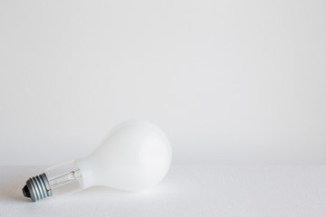 Old opaque glass light bulb on the gray background. Electricity consumption concept. Empty place for a text and other ideas.