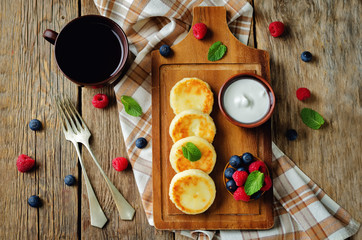 Fototapeta na wymiar Cottage cheese pancakes with honey, sour cream and berries