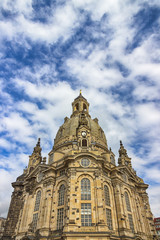 Fototapeta na wymiar Famous Church Frauenkirche in Dresden against a blue sky with white clouds. Fragment. Saxony, Germany