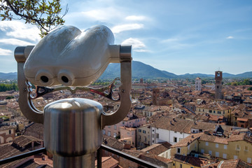 Cityscape with tourist binoculars, view of old town of Lucca, Italy