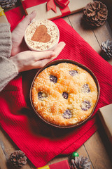 Female hands holding Christmas pie and cup of coffee