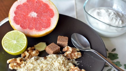Breakfast table arrangement with grapefruit, orange, lemon and ground walnut.