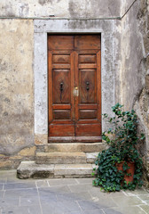 Fototapeta na wymiar Old weathered wooden door of village house, Tuscany, Italy.