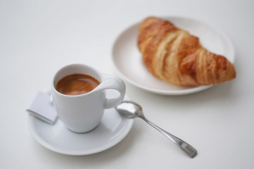 White coffee Cup on white background with a croissant.