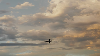 Passenger airplane taking off at sunset against the background of a very beautiful clouds.