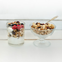 Granola with berries and yogurt on a white background. Traditional American Breakfast