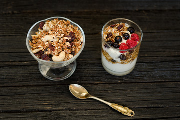 Granola with berries and yogurt on a black wooden table. Traditional American Breakfast