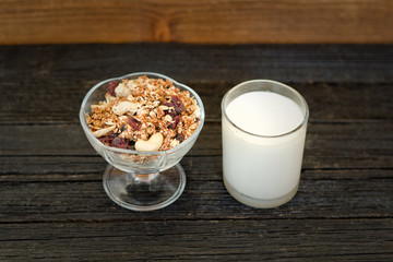 Glass of yogurt and granola on a black wooden table. Traditional American Breakfast