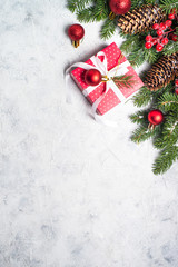 Fototapeta na wymiar Christmas background. Red christmas present box, fir tree branch and decorations.