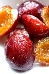 Plum frost lying on a white plate. Frost cold bright juicy lie. Water drops, ice, snow.