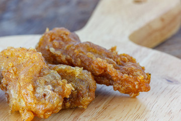 fried chicken wings on a wooden background.
