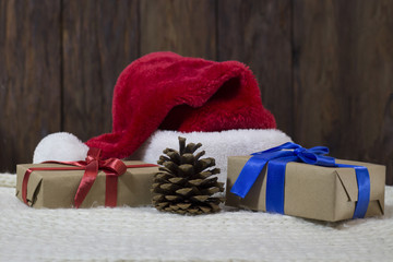 The Santa Claus hat, two boxes of gifts wrapped in kraft paper, tied with red and blue ribbons, a cone