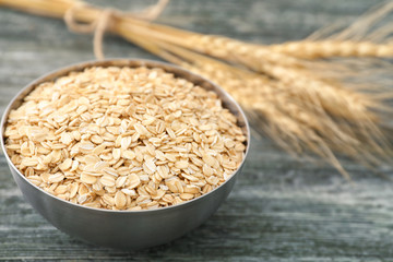 Bowl with oatmeal flakes on wooden background