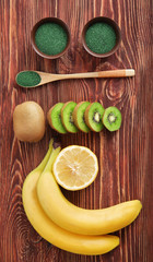 Composition with spirulina powder in spoon on wooden table