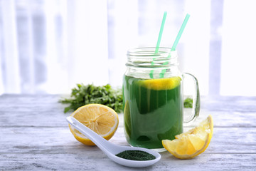 Mason jar with fresh spirulina drink on table
