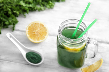 Mason jar with fresh spirulina drink on table