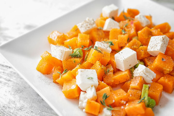 Plate with delicious sliced sweet potato on table