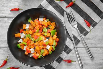 Plate with delicious sliced sweet potato on table