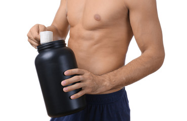 Naklejka premium Shirtless young man holding black jar with protein powder on white background