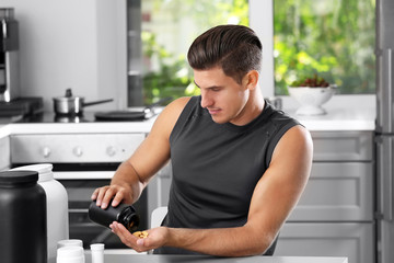Man holding jar with protein pills indoors