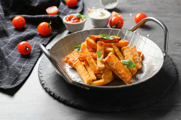 Pan with sweet potato fries on table