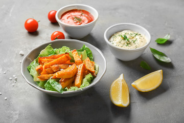 Plate with sweet potato fries on table