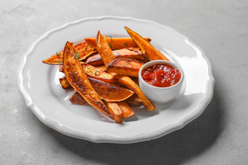 Plate with sweet potato fries on table
