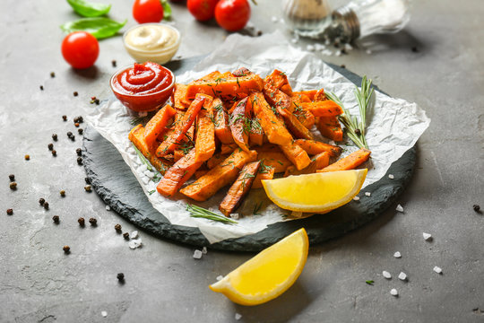 Slate plate with sweet potato fries on table
