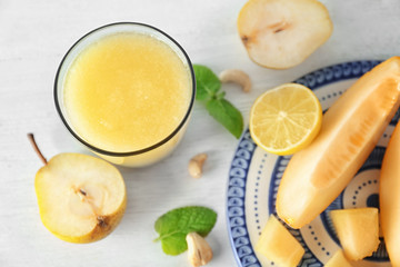 Composition with glass of fresh melon smoothie on table
