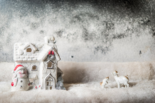 House toy with Santa Clouse and reindear covered with snow