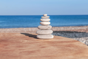 Beach round pebble stone set balance arrangement like zen symbol on wooden table